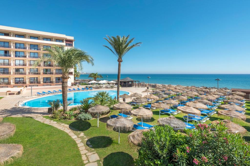 ośrodek z basenem, parasolami i oceanem w obiekcie VIK Gran Hotel Costa del Sol w mieście La Cala de Mijas