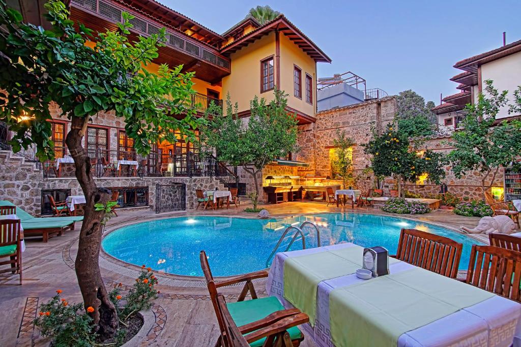 a swimming pool with a table and chairs next to a building at La Paloma Hotel in Antalya