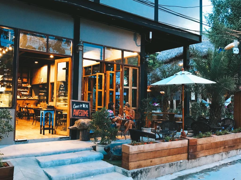 a restaurant with people sitting outside of a building at Bloom Cafe & Hostel in Ko Lipe