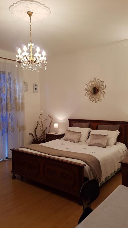 a bedroom with a large bed with a chandelier at Buio Pesto B&B in Ceparana