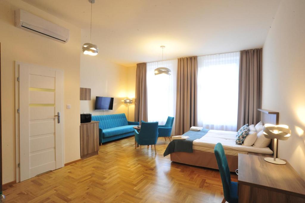 a hotel room with a bed and a living room at Kosmopolita Apartments in Kraków