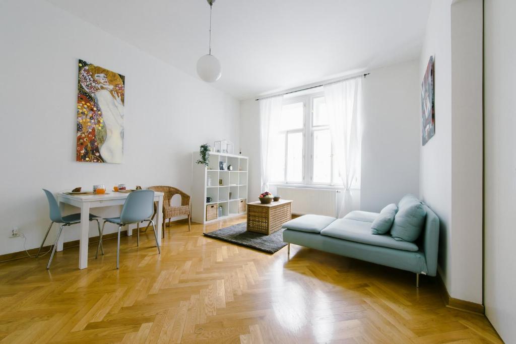 プラハにあるKubelíkova Apartmentsのリビングルーム(青いソファ、テーブル付)