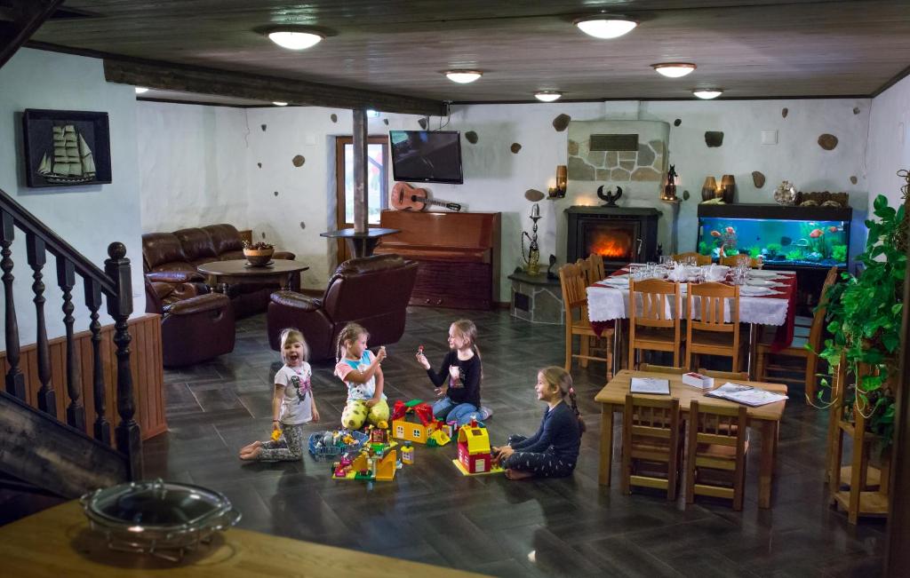 um grupo de crianças sentadas no chão numa sala de estar em Krapi Guesthouse em Treimani