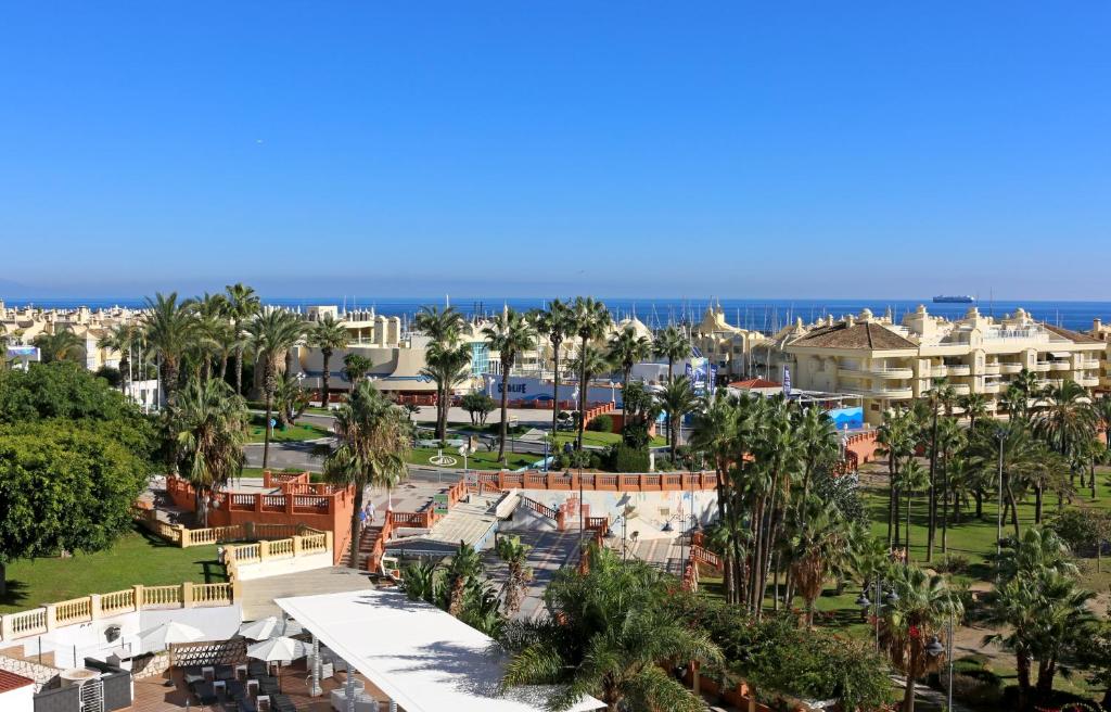 an aerial view of a resort with palm trees and the ocean at Apartamentos Tamarindos in Benalmádena