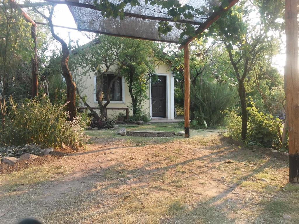 a white house with a porch and a yard at Aire del Cerro in Capilla del Monte