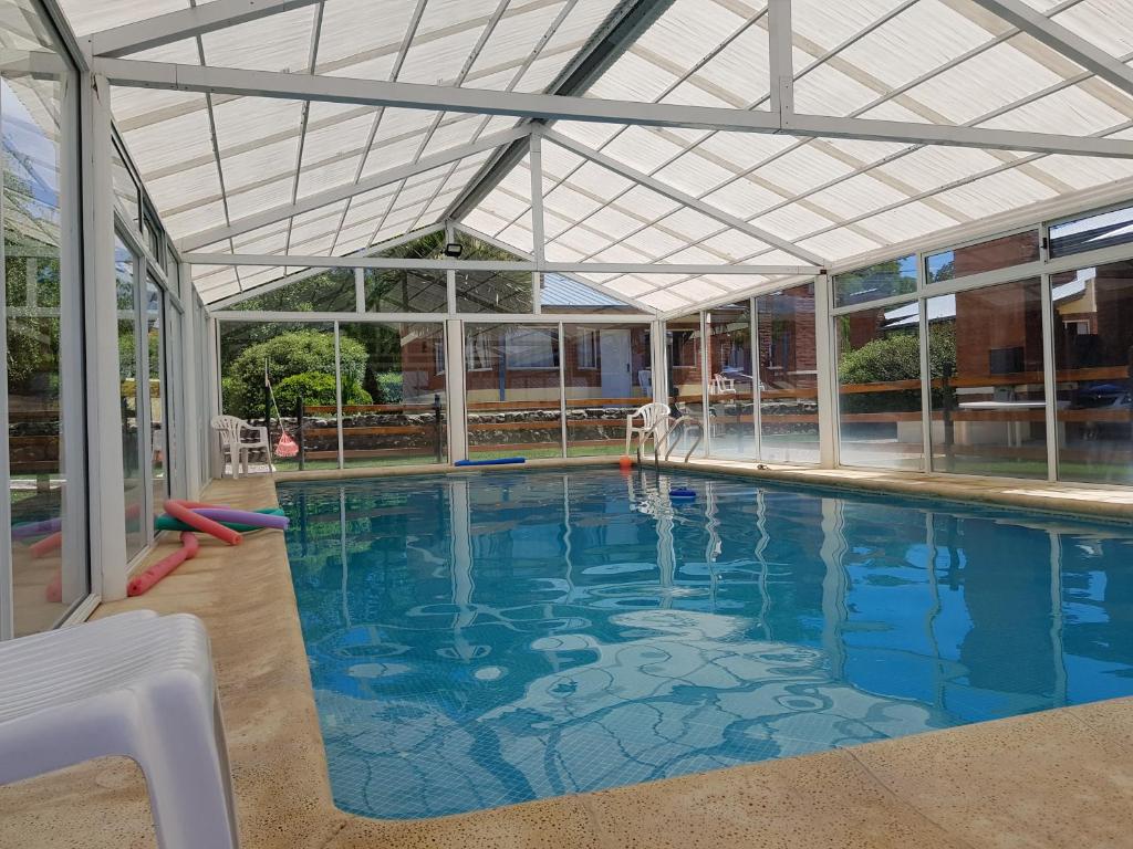a large swimming pool with a ceiling and windows at Complejo Don Osvaldo in Sierra de la Ventana