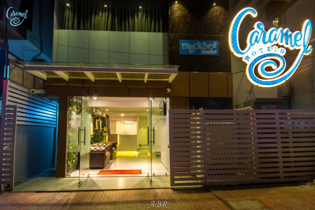 a entrance to a building with a neon sign at Caramel Hotels in Bangalore