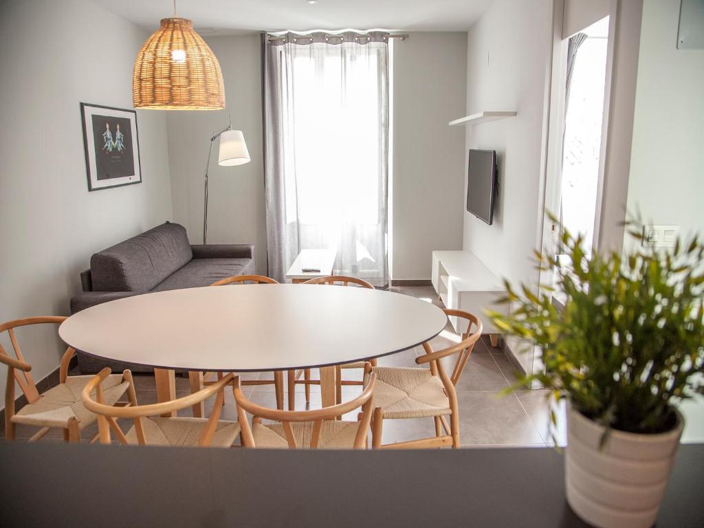 een woonkamer met een tafel en stoelen bij Flats Friends Soho Suites in Valencia