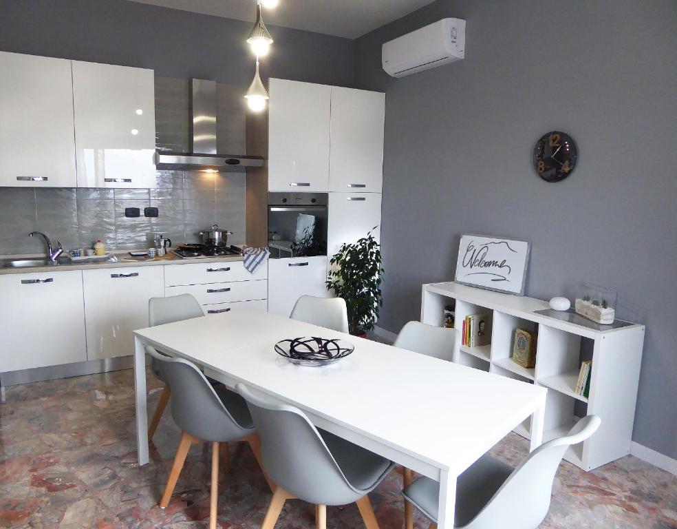 ナポリにあるLa Bella Vita Apartmentsの白いキッチン(白いテーブルと椅子付)