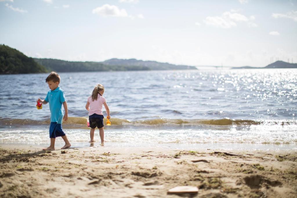 two children playing on the beach near the water at Hamre Familiecamping in Kristiansand