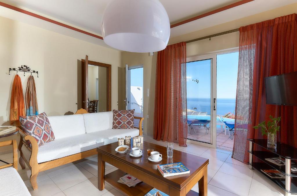 sala de estar con sofá blanco y mesa en Nymphes Luxury Apartments en Agia Pelagia