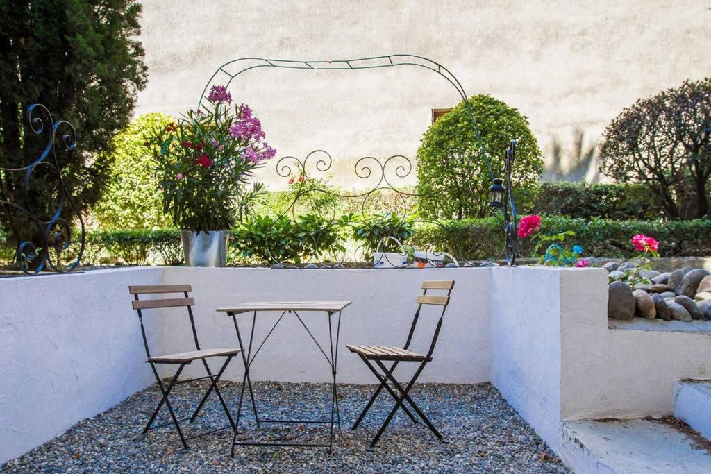3 chaises et une table dans un jardin dans l'établissement Le Joli Nid, à Toulouse