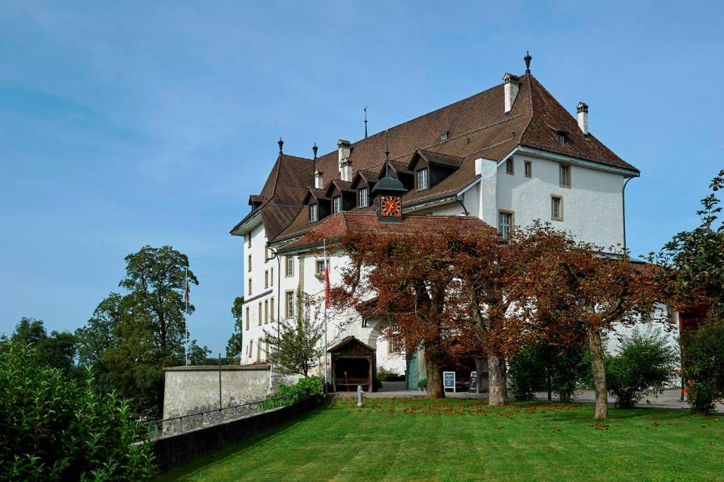 ein großes weißes Gebäude mit braunem Dach in der Unterkunft BnB SchlafSchloss in Sumiswald