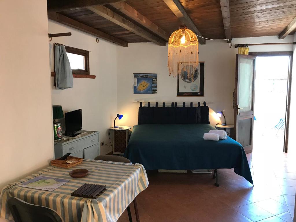 a bedroom with a bed and a table in it at Case del Tramonto in Ustica