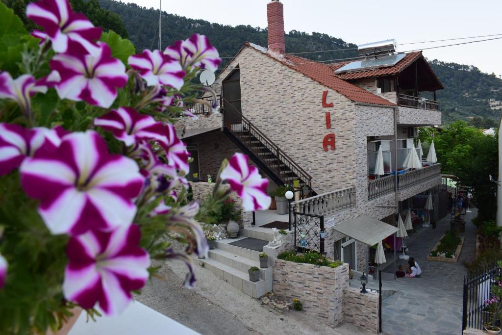 Un edificio con flores moradas en el frente. en Studios Lia Adults Only -Fully Renovated, en Chrysi Ammoudia