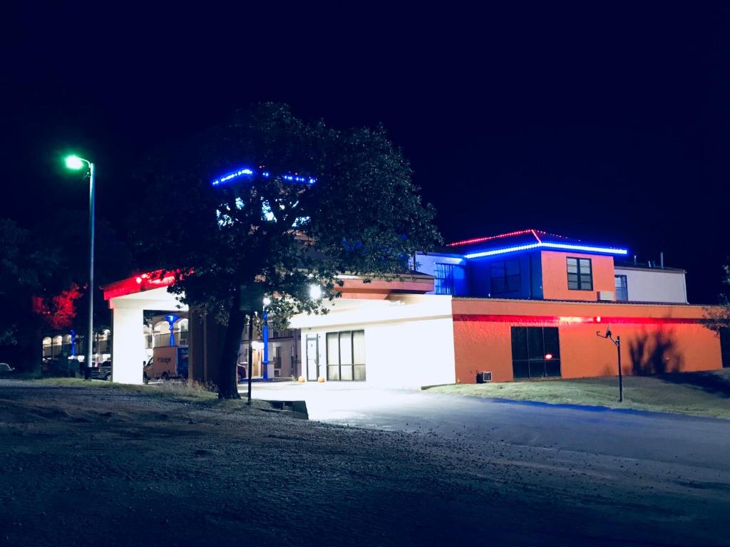 a building with a tree in front of it at night at Americas Best Value Inn Bowie in Bowie