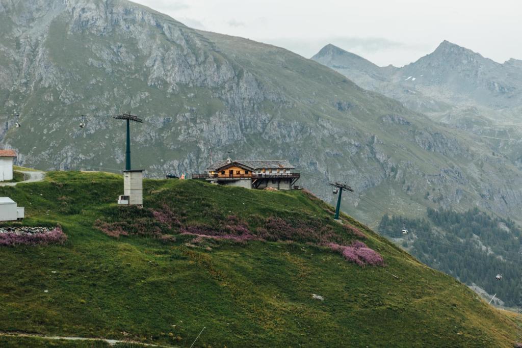 a house on top of a hill with a mountain at Albergo Ristoro Sitten in Gressoney-la-Trinité