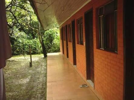 an empty hallway of a brick building with a sidewalk at Pousada do Carlito in Ilha do Mel