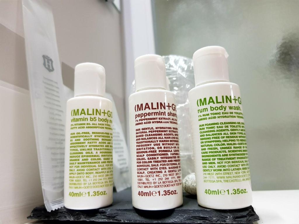 three bottles of moisturizers sitting on a shelf at Hotel Aurora Duino in Duino
