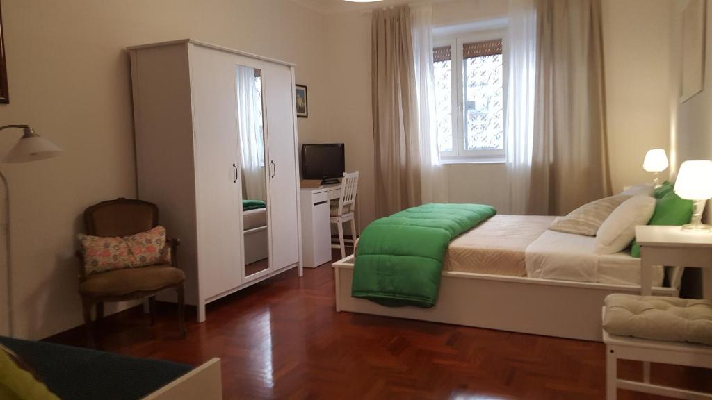 ローマにあるhomedieciのベッドルーム1室(緑の毛布付きのベッド1台付)