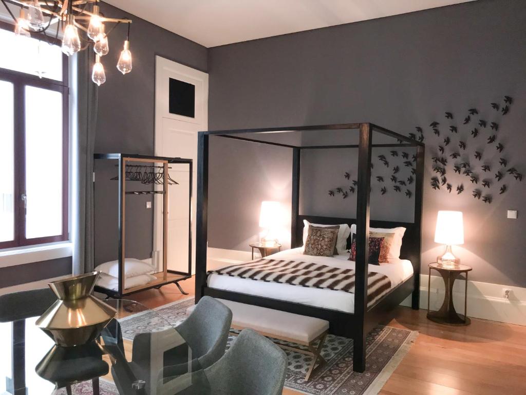 a bedroom with a canopy bed and a chair at Oporto Chic & Cozy - Flores in Porto