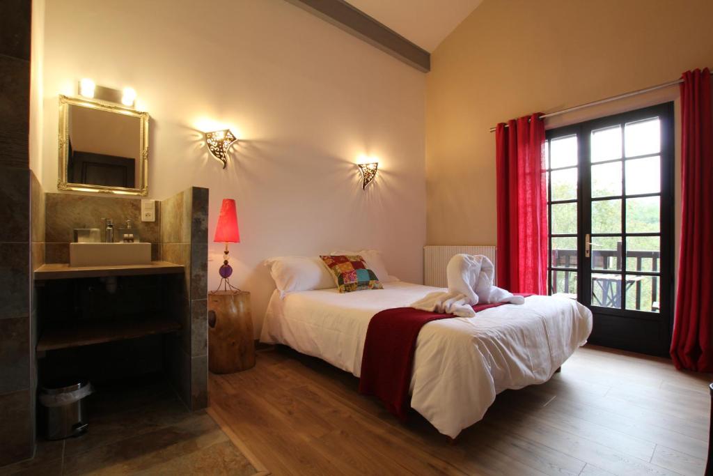 a bedroom with a bed and a sink and a window at Etxe goxoan chambres d'hôtes avec cuisine été équipée commune et jaccuzi in Itxassou