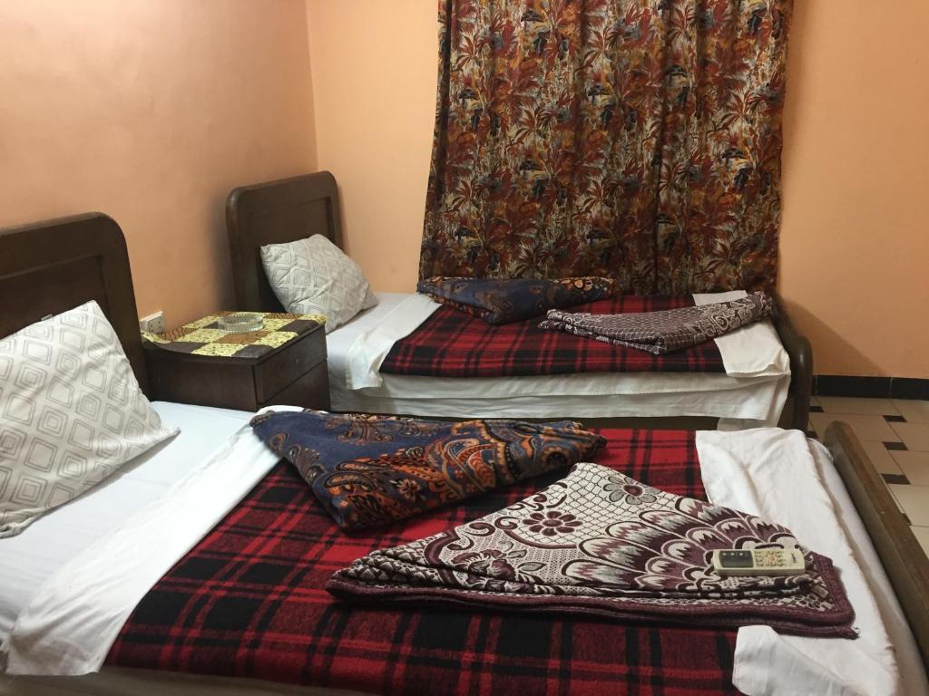two beds with pillows on them in a room at Venus Hostel in Cairo