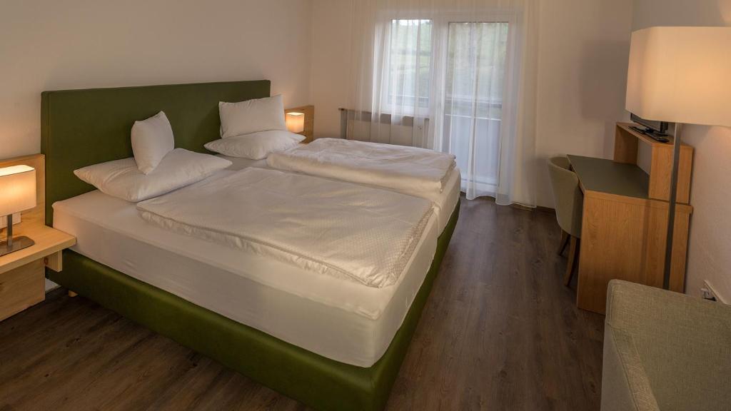 a bedroom with a large bed with a green headboard at Hotel Grünes Türl in Bad Schallerbach