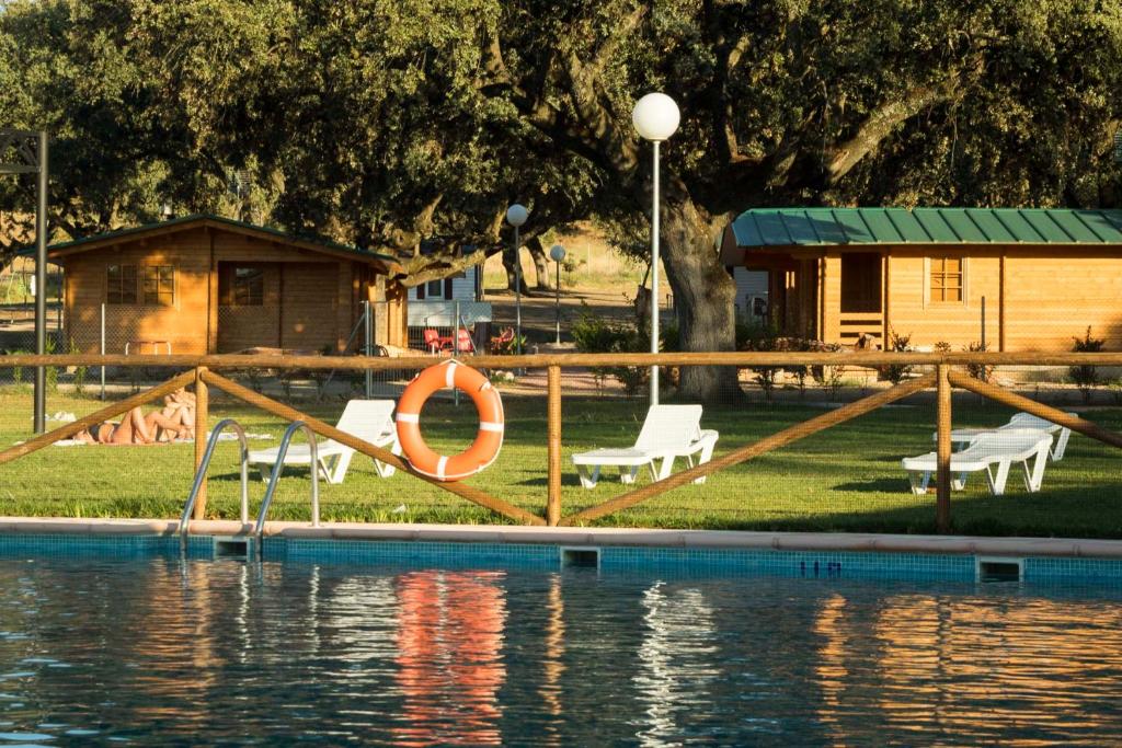 a pool with a life preserver and chairs next to the water at Complejo The Dreams in Cazalegas