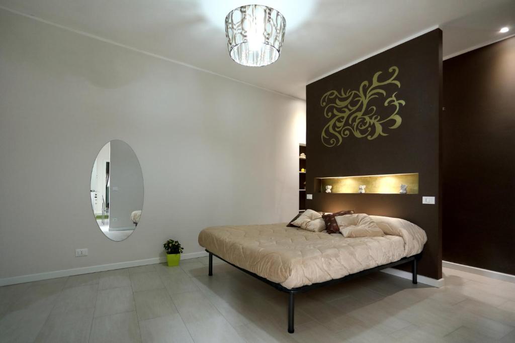una camera con letto e lampadario a braccio di Casa Le Nereidi a Castellammare del Golfo