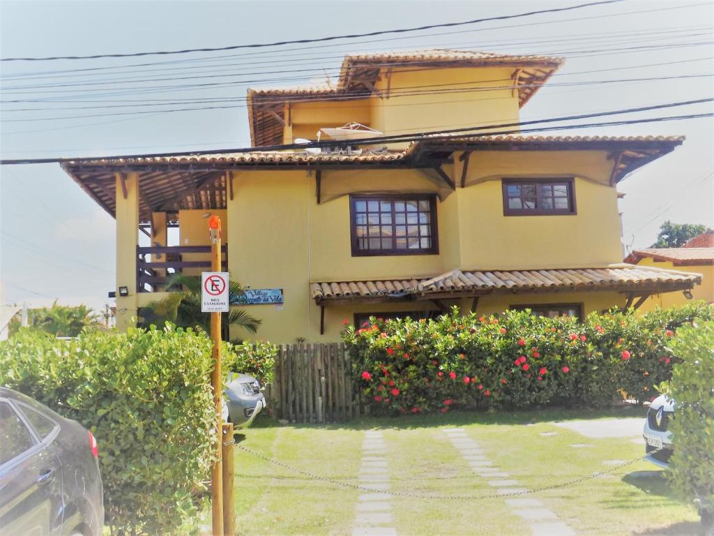 una casa amarilla sin señal de estacionamiento delante de ella en Apart para até 6 Pessoas - PF, en Praia do Forte