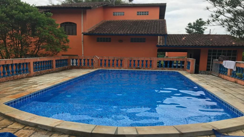 a large blue swimming pool in front of a house at Chacará com piscina climatizada 1 hora de SP Mogi das Cruzes,até 30 pessoas in Mogi das Cruzes