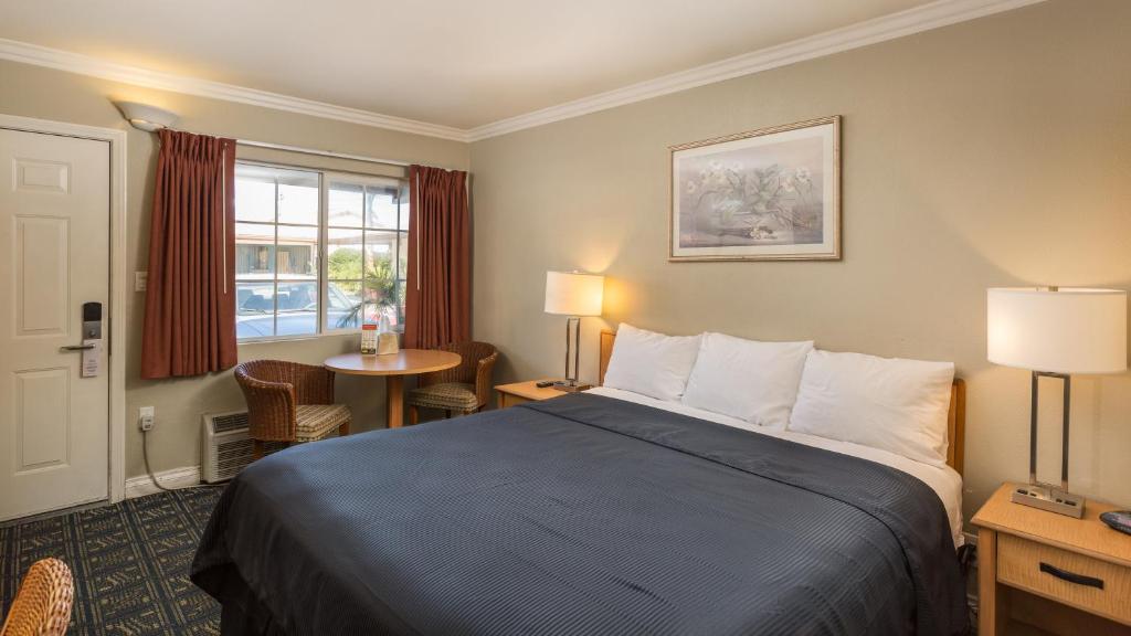 a hotel room with a bed and a window at Harbor Motel in Anaheim