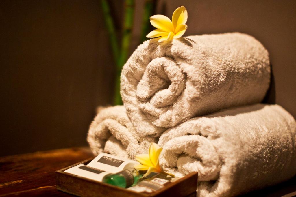 a pile of towels and flowers on a table at JavaCove Beach Hotel in Batukaras