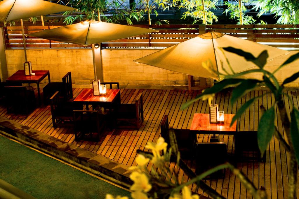 a restaurant with tables and umbrellas on a patio at JavaCove Beach Hotel in Batukaras