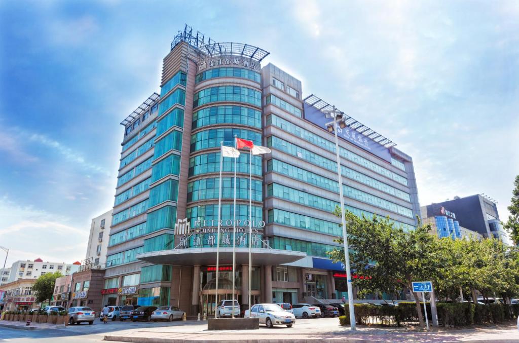 a tall building with two flags in front of it at Metropolo, Qingdao, Chengyang People's Government in Qingdao