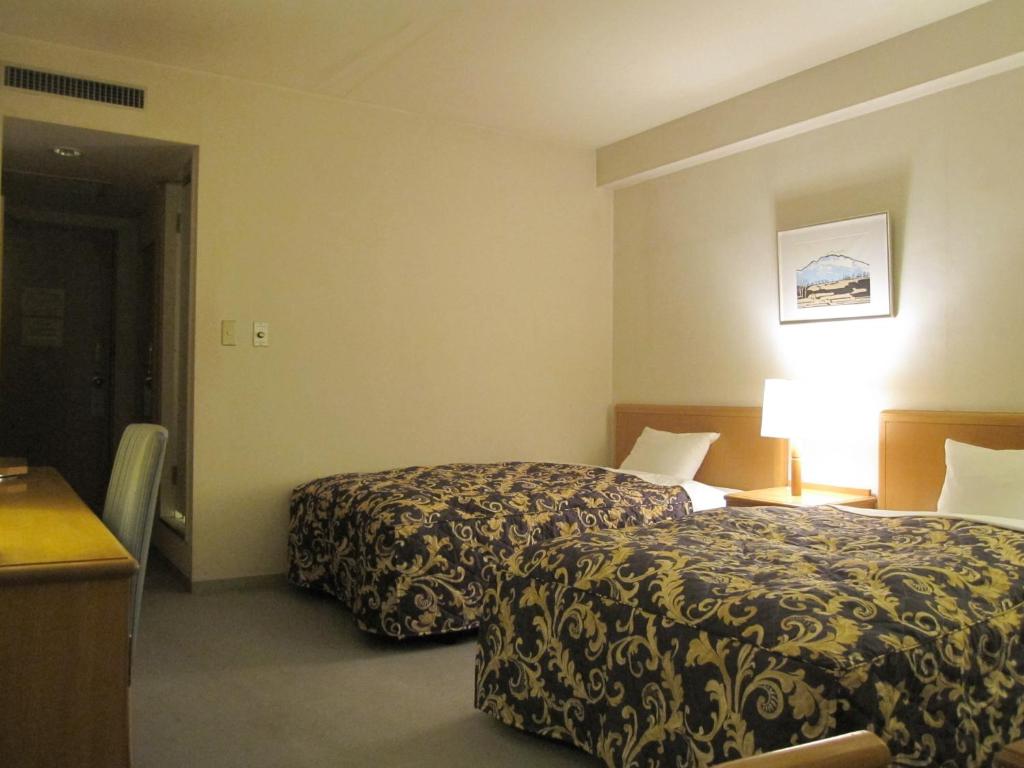 Postel nebo postele na pokoji v ubytování Saku Grand Hotel