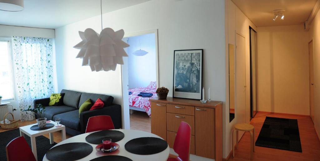uma sala de estar com um sofá, uma mesa e cadeiras em Aliisa's Apartment em Rovaniemi