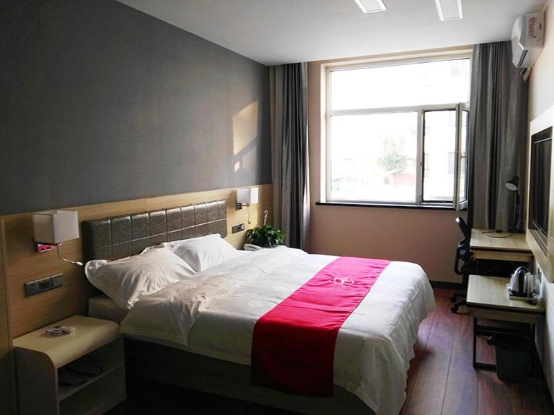 a bedroom with a large bed and a window at Thank Inn Chain Hotel Inner Mongolia Tongliao Horqin Dis. Tienan Kundulun Ave in Tongliao