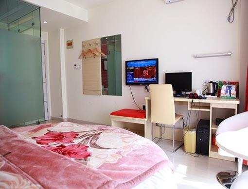 a bedroom with a bed and a desk and a computer at Thank Inn Chain Hotel Jiangsu Yancheng Xiangshui Town Qinghuayuan in Xiangshui