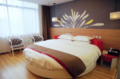 een slaapkamer met een groot bed in een kamer bij Thank Inn Chain Hotel Jiangsu Zhenjiang Danyang Train Station in Jinglin