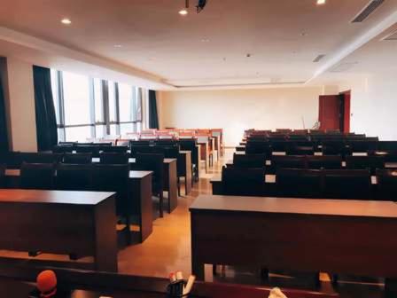 an empty lecture room with tables and chairs at Thank Inn Chain Hotel Jiangsu Yancheng Dongtai Huiyin Plaza in Xintuan