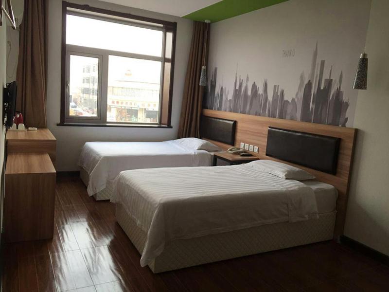 a hotel room with two beds and a window at Thank Inn Chain Hotel Tianjin Jixian Zhongchang Road in Jixian