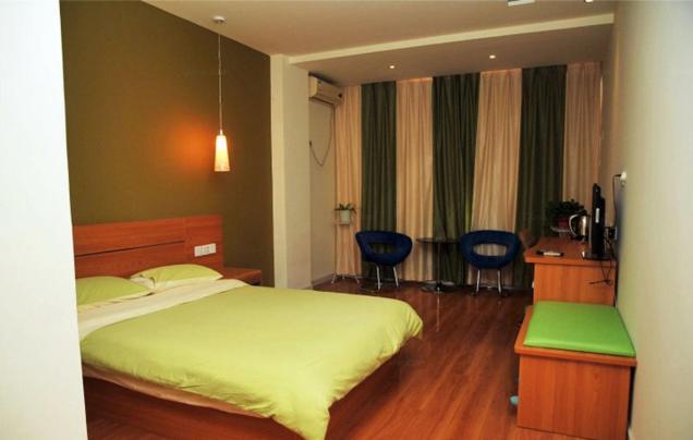 1 dormitorio con 1 cama y 2 sillas azules en Thank Inn Chain Hotel Shandong Zibo Mingqing Street, en Zibo
