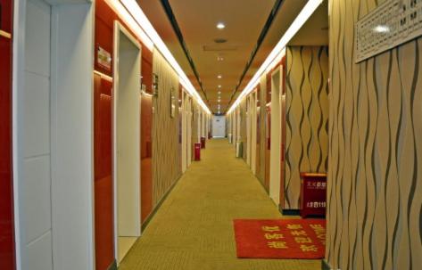 a hallway in a building with a red rug on the floor at Thank Inn Chain Hotel Hebei Shijiazhuang Zhengding West Changshan Road in Zhengding