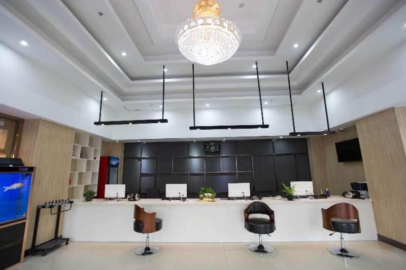 um quarto amplo com cadeiras, uma mesa e um lustre em Thank Inn Plus Hotel Hebei Tangshan Road South District Train Station em Tangshan