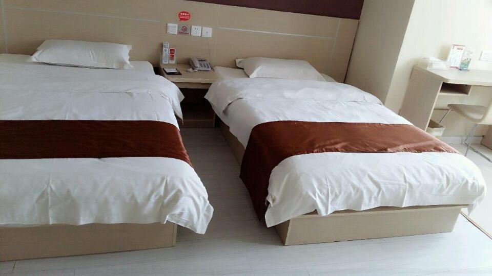 a room with two beds and a desk in it at Thank Inn Chain Hotel Jiangsu Huaian Lianshui Gaogou Town No.1 Street in Duimatou