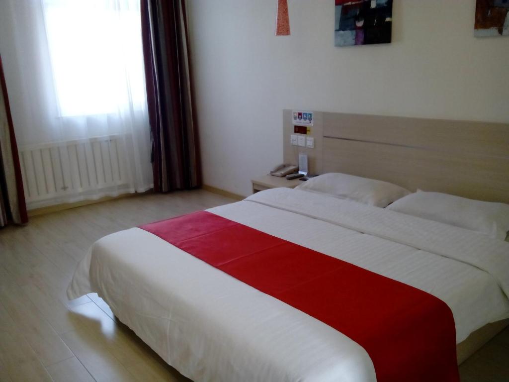 a bedroom with a red and white bed with a window at Thank Inn Chain Hotel Shandong Rongchengshi Island South Huanghai Road in Dongshan
