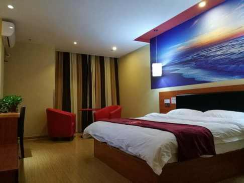 a bedroom with a bed with a large painting on the wall at Thank Inn Chain Hotel Zhejiang Huzhou Changxing Town Qingfang City in Jiapu