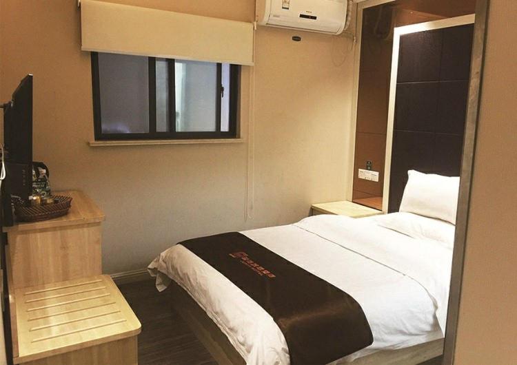 sypialnia z dużym łóżkiem i oknem w obiekcie JUNYI Hotel Jiangsu Xuzhou Middle Xiyuan Road w mieście Xuzhou